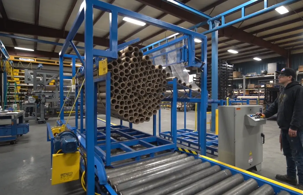 Custom Integrated Conveyor Systems with Core Rack and Strap Unloader System for Paper Operations Custom Integrated Conveyor Systems with Core Rack and Strap Unloader System for Paper Operations